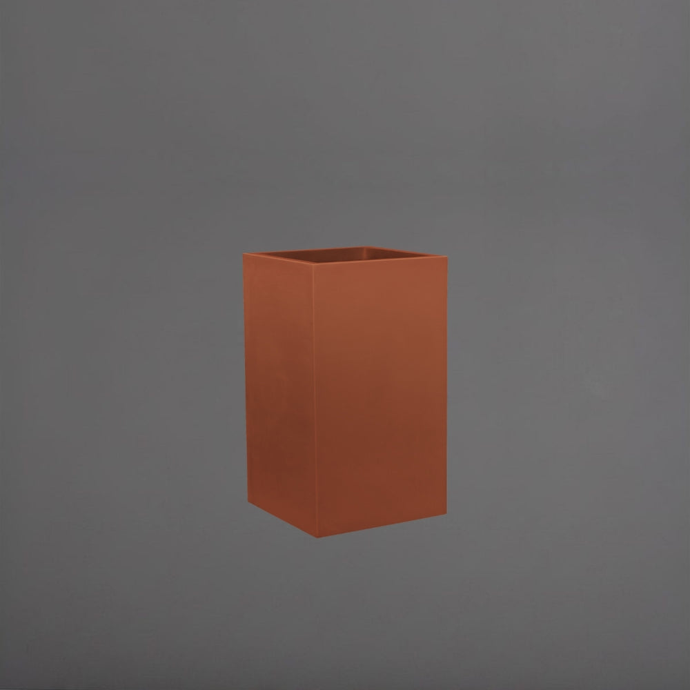 Tolga Corner Fiberglass Planter in matte terra cotta against gray background