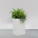 Torino Corner Fiberglass Planter filled with plants against gray background.