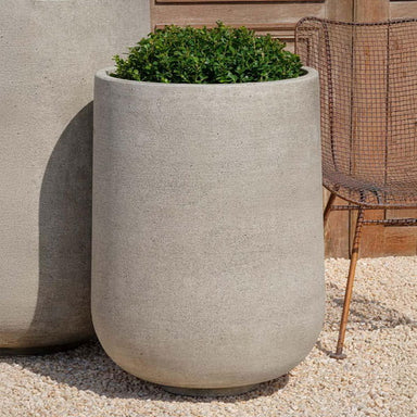 Tribeca Tall Planter, 30 inch on gravel filled with plants.
