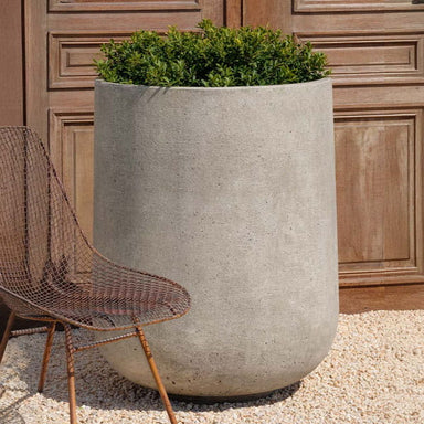 Tribeca Tall Planter, 36 inch on gravel filled with plants.