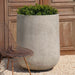 Tribeca Tall Planter, 36 inch on gravel filled with plants.