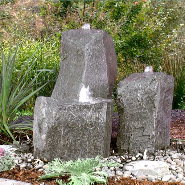 Twisting Cascade Triple Fountain Kit on black pebbles in the backyard