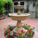 Uva Two Tier Fountain surrounded with red flowers.