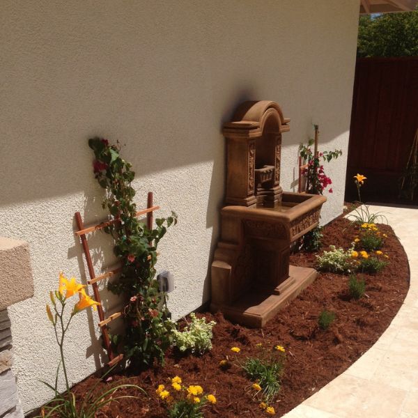Uva Wall Fountain in action in the backyard sideview.