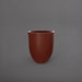 Valencia Tapered Round Fiberglass Planter in matte terra cotta against gray background.