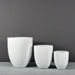 Valencia Tapered Round Fiberglass Planter on concrete shown with different sizes.