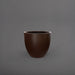 Wannsee Extra Large Round Fiberglass Planter in matte dark brown against gray background.