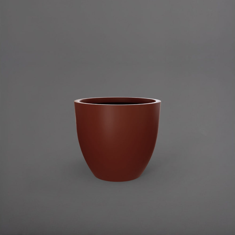 Wannsee Extra Large Round Fiberglass Planter in matte terra cotta against gray background.