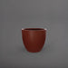 Wannsee Extra Large Round Fiberglass Planter in matte terra cotta against gray background.