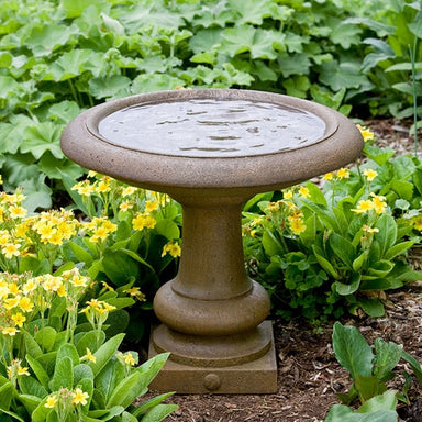 Williamsburg Summer House Birdbath against yellow flowers in the backyard