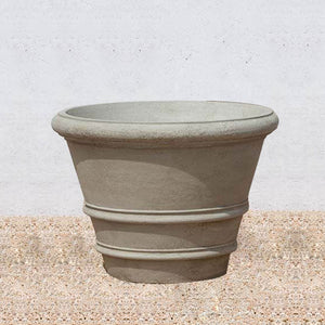 Classic Rolled Rim 31.5" Planter on gravel against cream wall