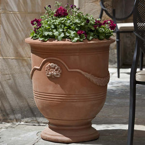 Coquille Anduze Urn S/3 Terra Rosa filled with red flowers in the backyard