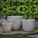 Dimple Glaze Planter S/3 Antico Terra Cotta against leaves on wall in the backyard