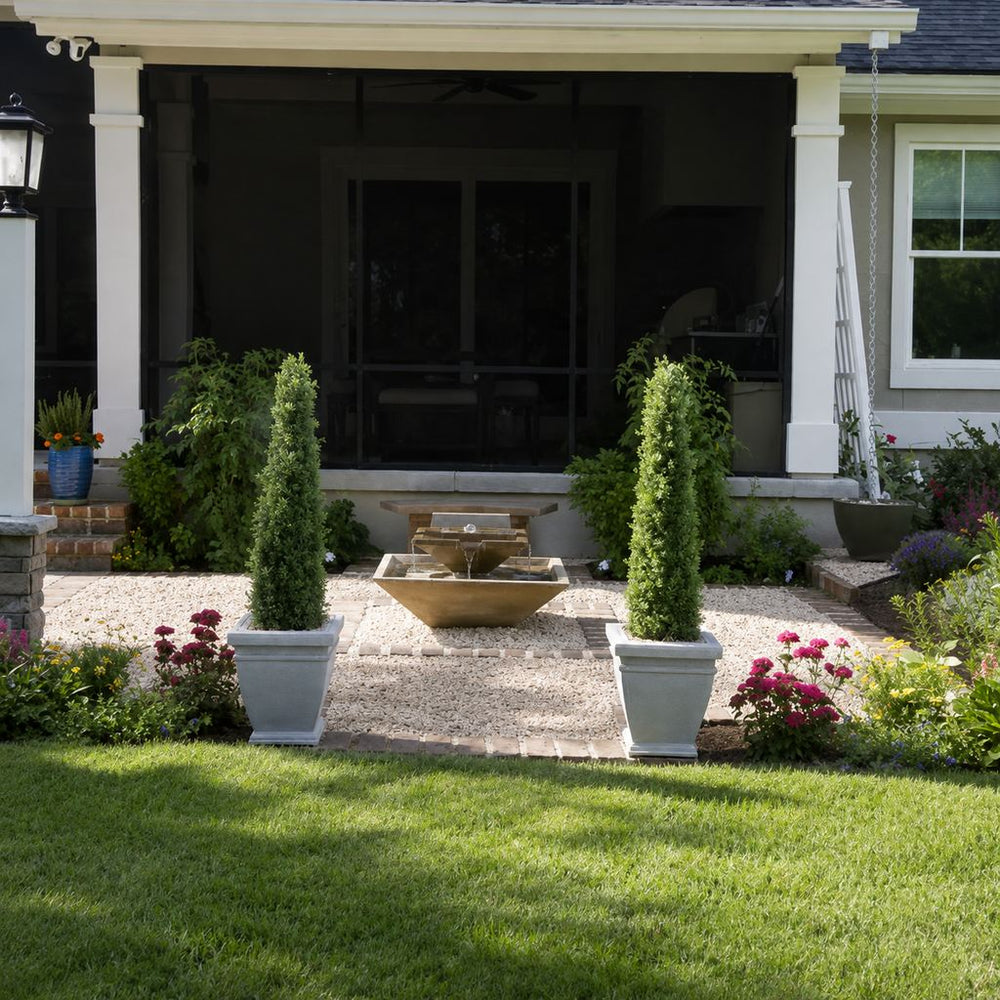facet fountain on gravel patio running surrounded by plants and flowers