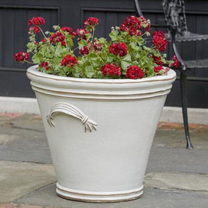 Fluted Handle Planter Antique White S/3 on concrete filled with red flowers