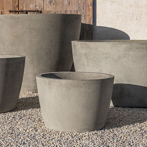 four different sized greystone planters on gravel