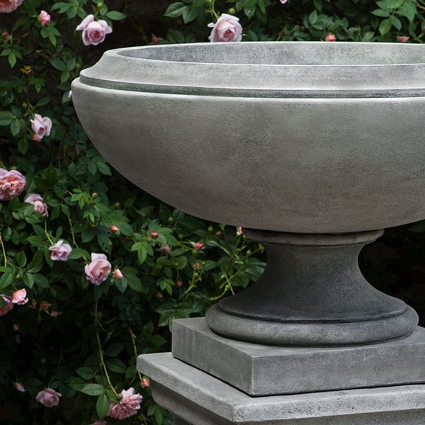 Jensen Urn, Large against pink flowers with green leaves upclose cropped