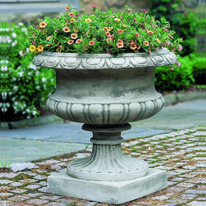 Lanciano Urn filled with flower against green plants