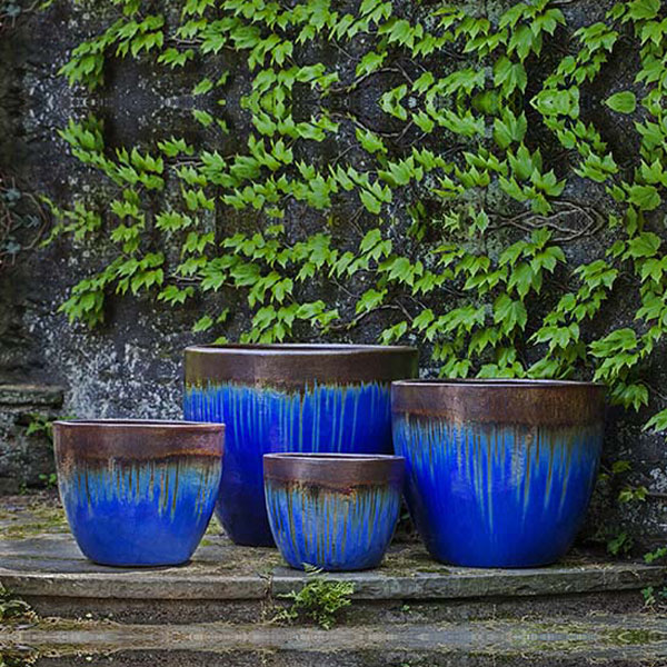 Marcel Planter Bronze Blue S/4 on concrete against wall with leaves