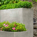 Metro Box Planter filled with pink flowers beside tall planter with plants upclose