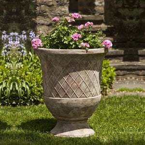 Pomezio Urn - Antico Terra Cotta - S/2 filled with pink flowers in the backyard