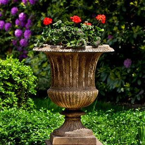 Smithsonian Classical Urn filled with red flowers in the backyard upclose