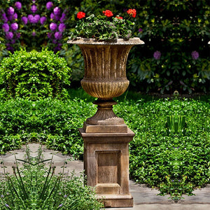 Smithsonian Classical Urn filled with red flowers in the backyard