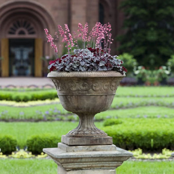 Smithsonian Foliated Scroll Urn on stone in the backyard