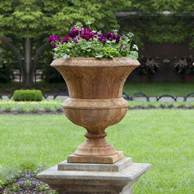 Smithsonian Flight of Fancy Urn filled with purple flowers in the backyard