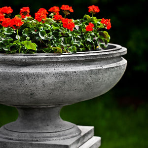 St. Louis Planter on pedestal filled with red flowers upclose