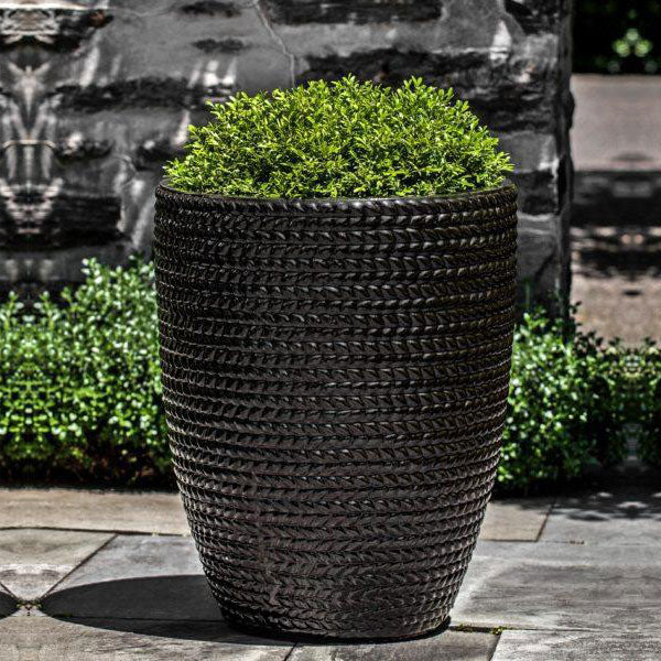 Tall Sisal Weave Planter Cola filled with plants in the backyard 