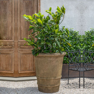 Urbino Planter, Extra Large filled with plants beside black chair
