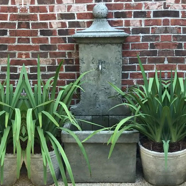 vence wall fountain against red brick wal