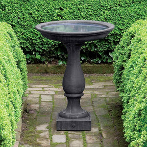 Williamsburg Candlestand Birdbath surrounded with plants in the backyard