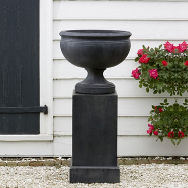 Williamsburg Plantation Urn on gravel near a flower plant