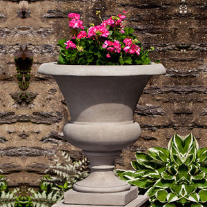 Wilton Urn filled with pink flowers in the backyard upclose
